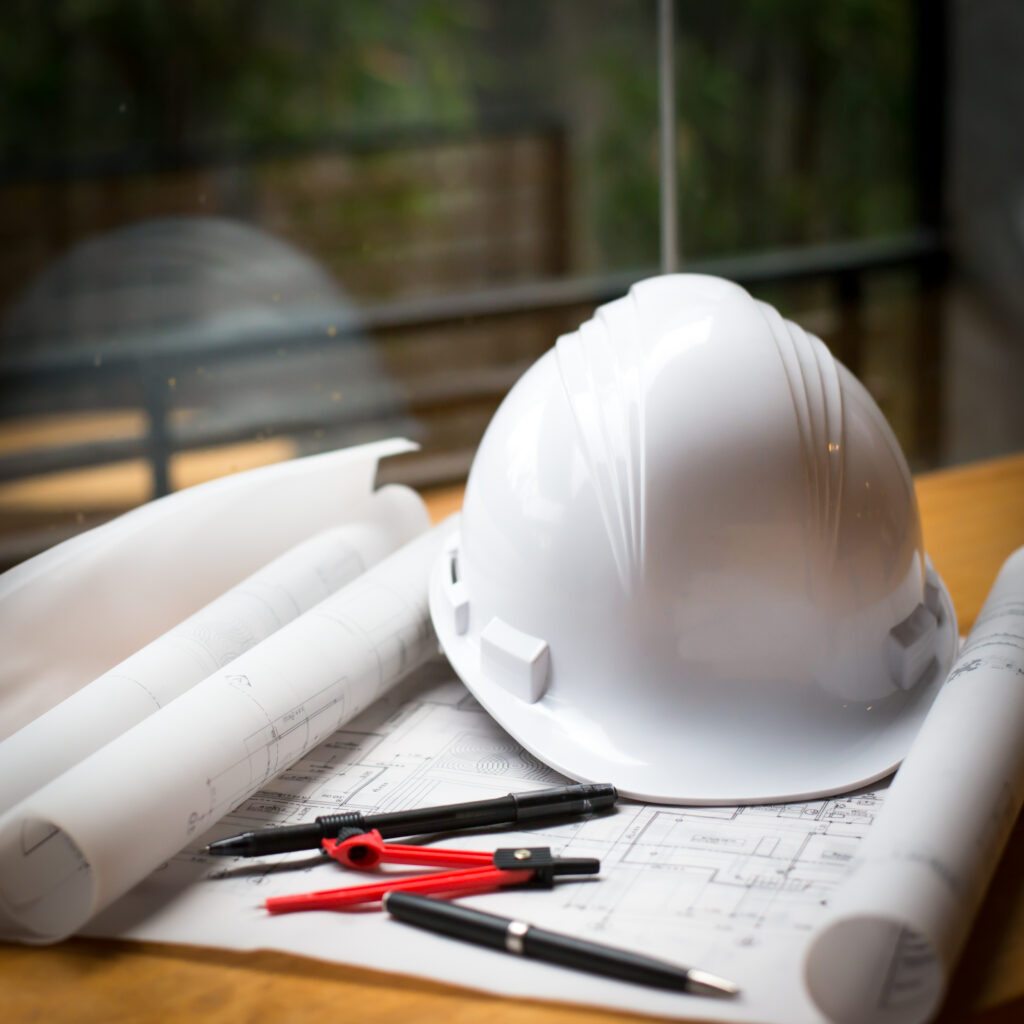 Conceito de construção. Capacete, plantas e materiais de escrita.